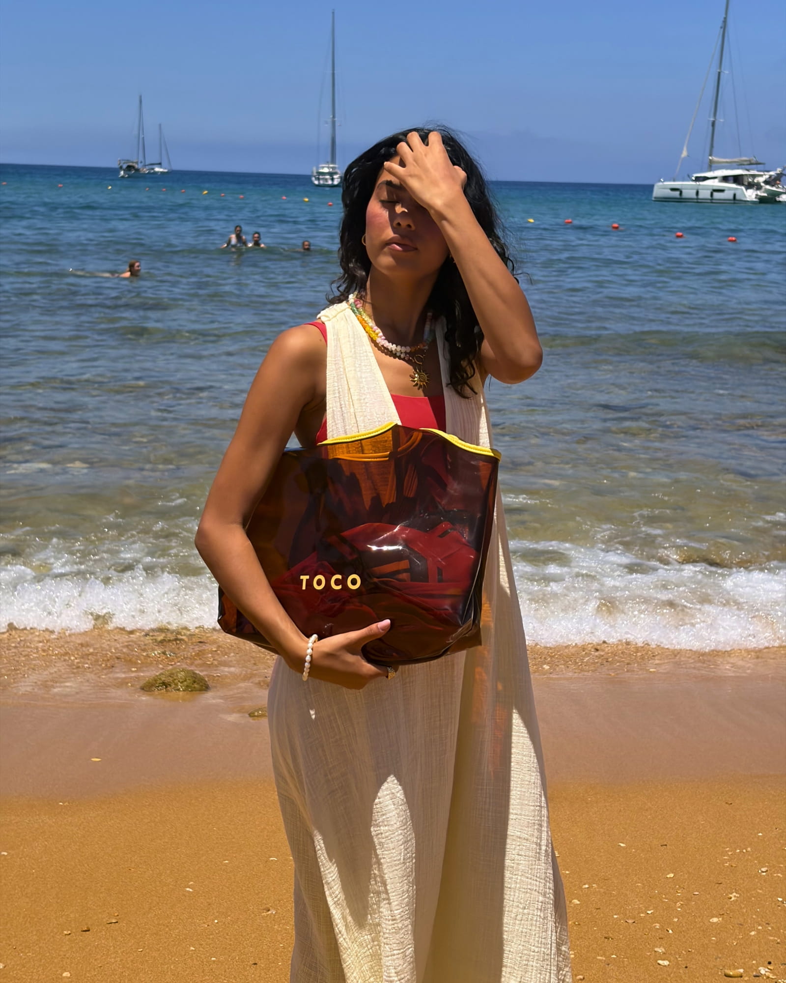 Front view of the Toco amber jelly beach tote with gold logo and yellow handles